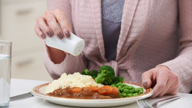 femme rajoute du sel à son plat