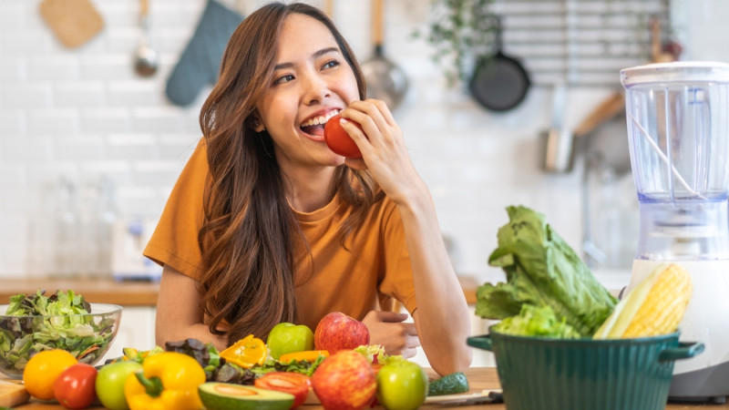 Femme qui mange des fruits et des légumes