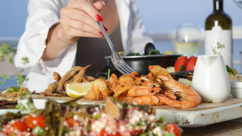 personne qui mange plateau fruits de mer